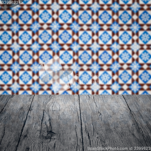 Image of Wood table top and blur vintage ceramic tile pattern wall