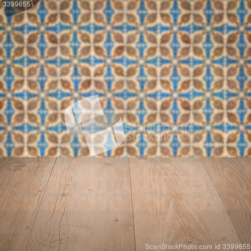 Image of Wood table top and blur vintage ceramic tile pattern wall