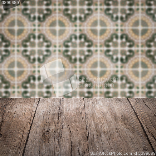 Image of Wood table top and blur vintage ceramic tile pattern wall