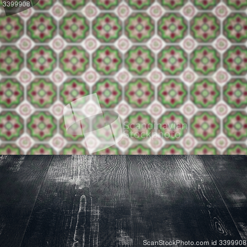 Image of Wood table top and blur vintage ceramic tile pattern wall