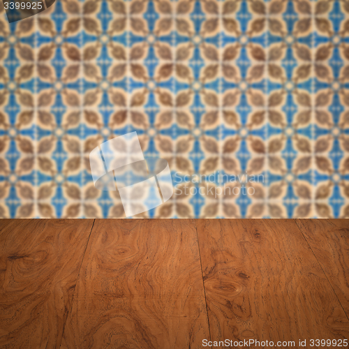 Image of Wood table top and blur vintage ceramic tile pattern wall