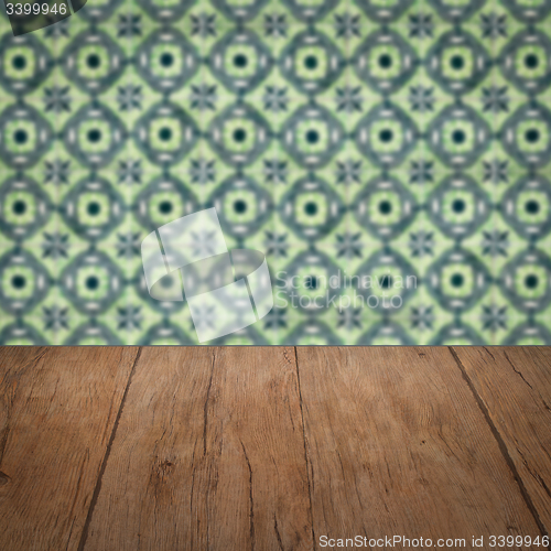 Image of Wood table top and blur vintage ceramic tile pattern wall