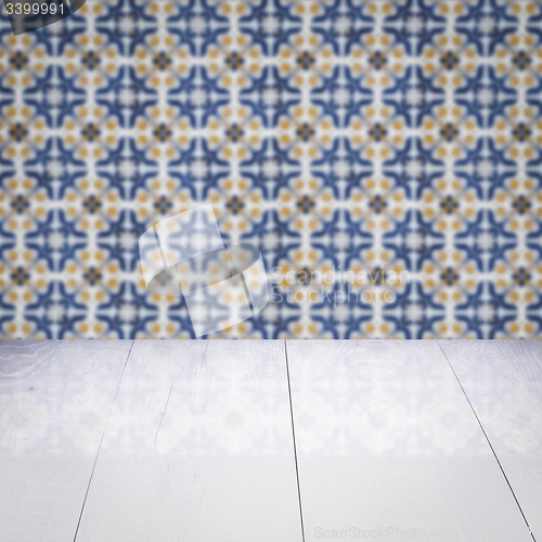 Image of Wood table top and blur vintage ceramic tile pattern wall