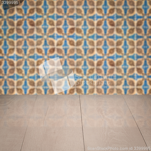 Image of Wood table top and blur vintage ceramic tile pattern wall