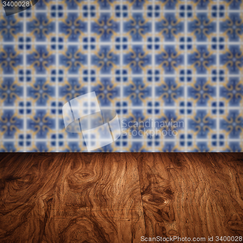 Image of Wood table top and blur vintage ceramic tile pattern wall