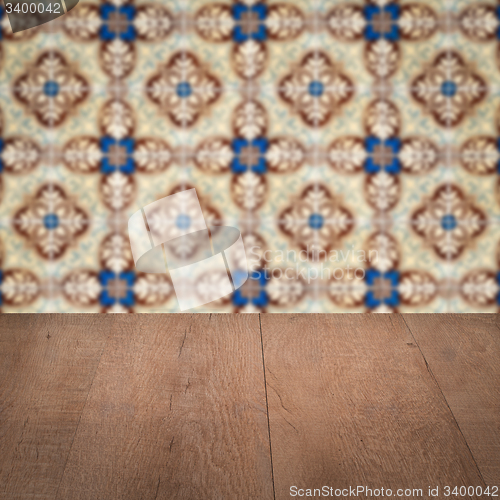 Image of Wood table top and blur vintage ceramic tile pattern wall