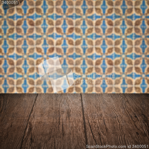 Image of Wood table top and blur vintage ceramic tile pattern wall