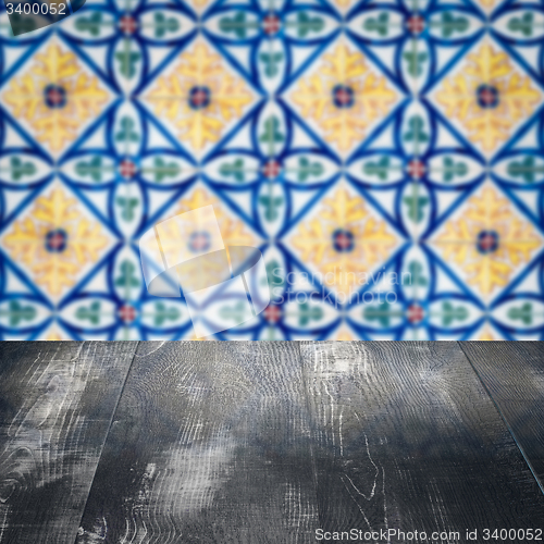 Image of Wood table top and blur vintage ceramic tile pattern wall