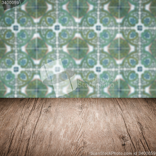 Image of Wood table top and blur vintage ceramic tile pattern wall