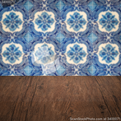 Image of Wood table top and blur vintage ceramic tile pattern wall