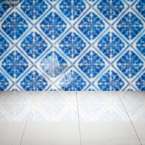 Image of Wood table top and blur vintage ceramic tile pattern wall