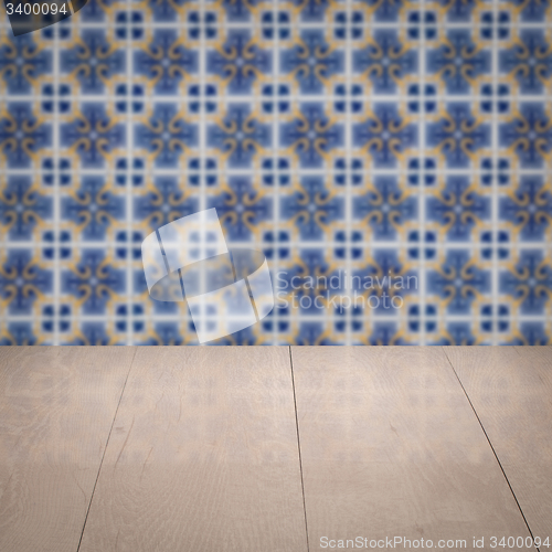 Image of Wood table top and blur vintage ceramic tile pattern wall