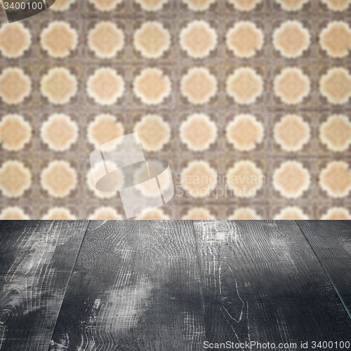 Image of Wood table top and blur vintage ceramic tile pattern wall