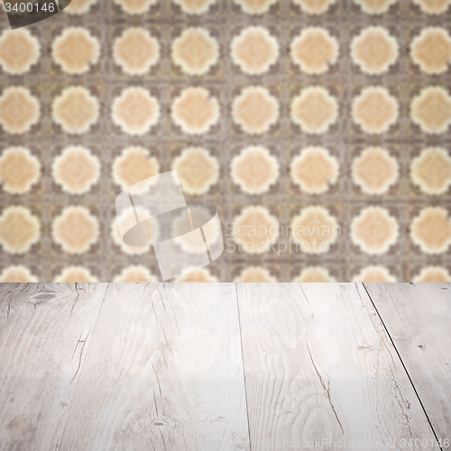 Image of Wood table top and blur vintage ceramic tile pattern wall