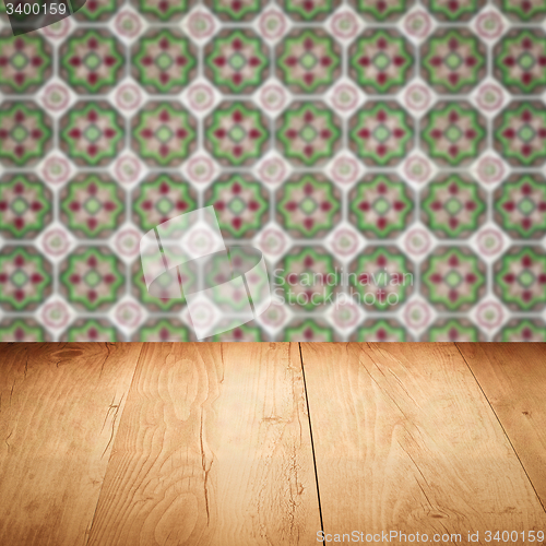 Image of Wood table top and blur vintage ceramic tile pattern wall