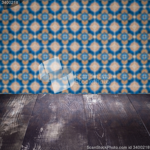 Image of Wood table top and blur vintage ceramic tile pattern wall
