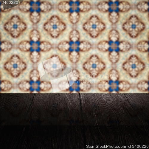 Image of Wood table top and blur vintage ceramic tile pattern wall