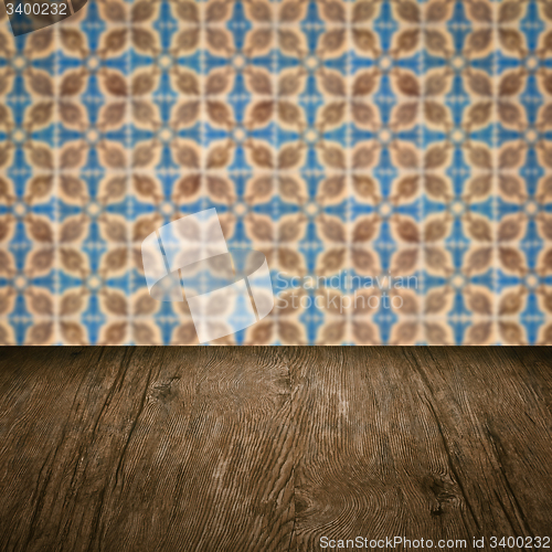 Image of Wood table top and blur vintage ceramic tile pattern wall