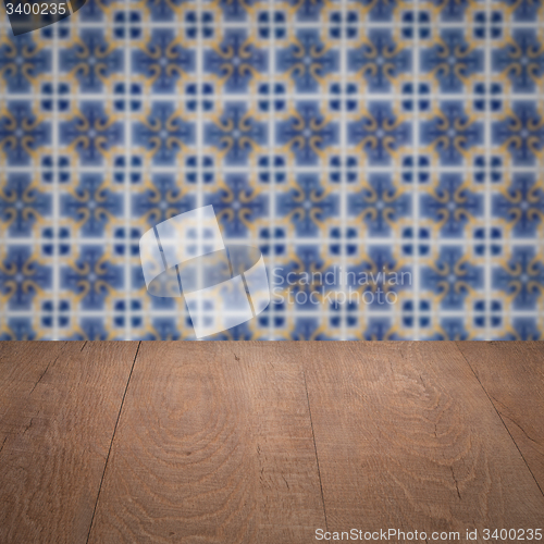 Image of Wood table top and blur vintage ceramic tile pattern wall
