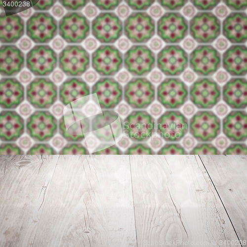 Image of Wood table top and blur vintage ceramic tile pattern wall