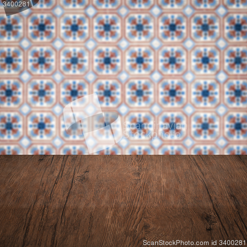 Image of Wood table top and blur vintage ceramic tile pattern wall
