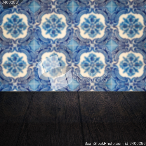 Image of Wood table top and blur vintage ceramic tile pattern wall
