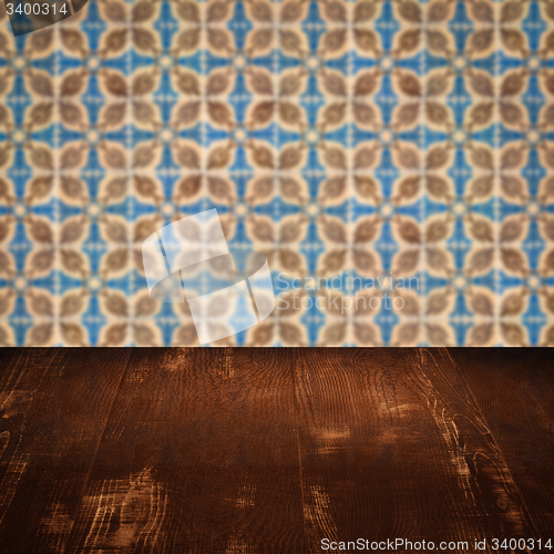 Image of Wood table top and blur vintage ceramic tile pattern wall