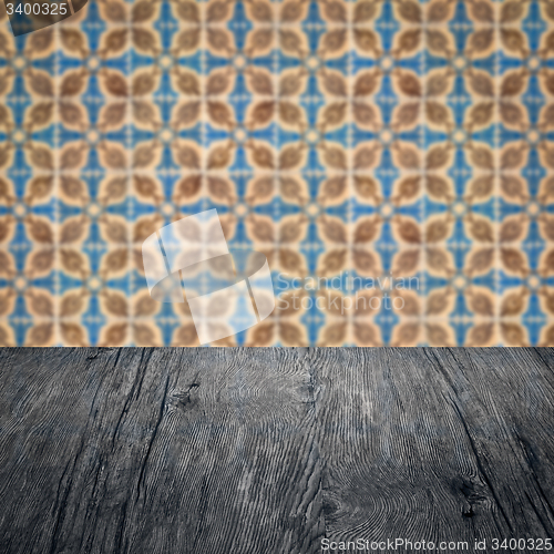 Image of Wood table top and blur vintage ceramic tile pattern wall