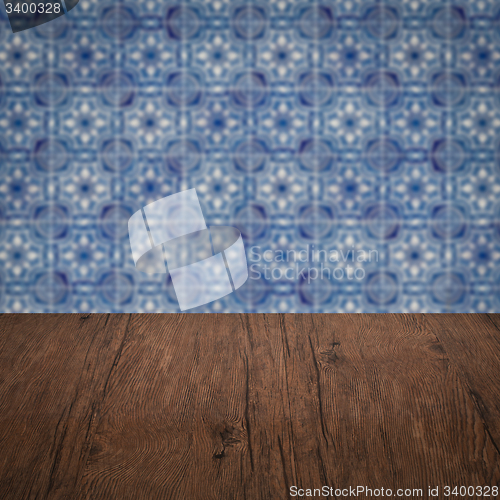 Image of Wood table top and blur vintage ceramic tile pattern wall
