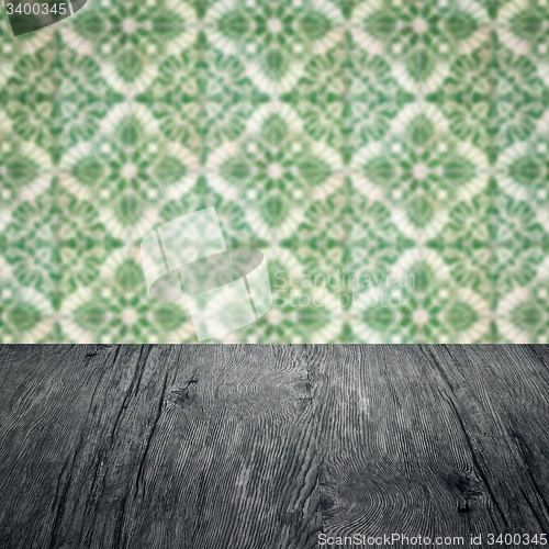 Image of Wood table top and blur vintage ceramic tile pattern wall