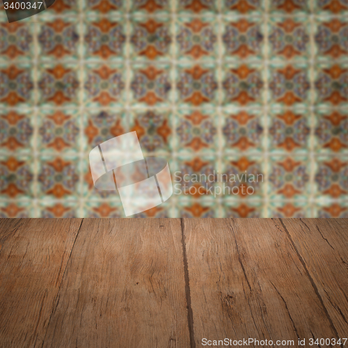 Image of Wood table top and blur vintage ceramic tile pattern wall