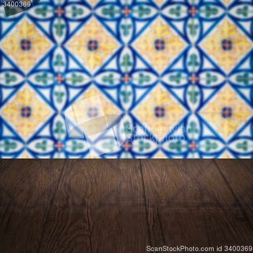 Image of Wood table top and blur vintage ceramic tile pattern wall