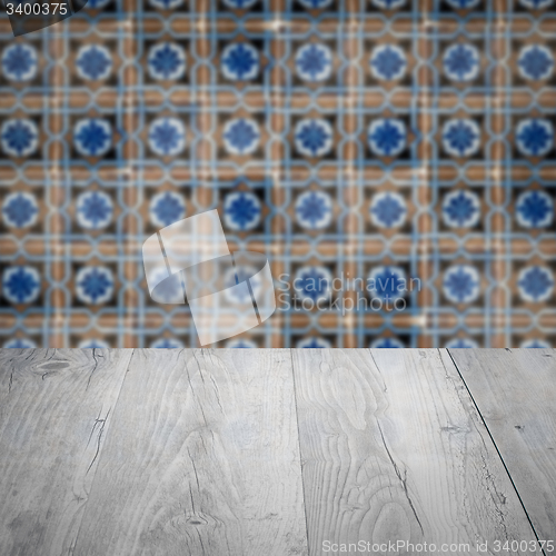 Image of Wood table top and blur vintage ceramic tile pattern wall