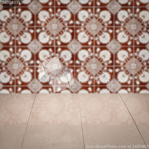 Image of Wood table top and blur vintage ceramic tile pattern wall