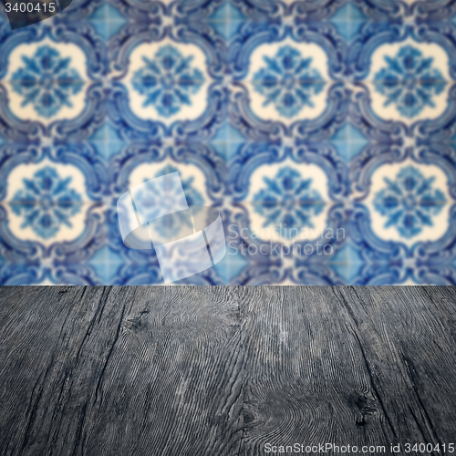 Image of Wood table top and blur vintage ceramic tile pattern wall