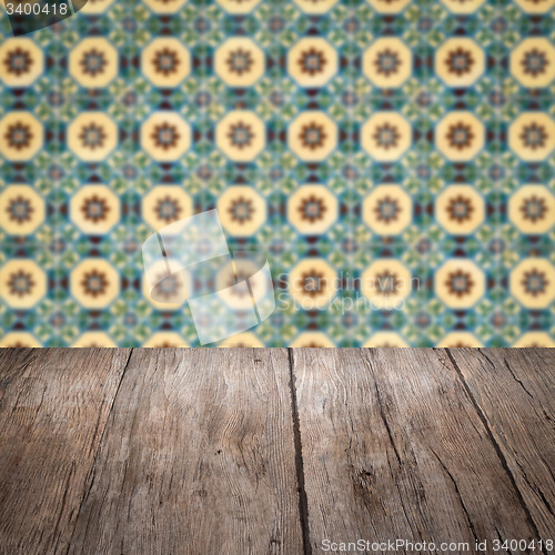 Image of Wood table top and blur vintage ceramic tile pattern wall