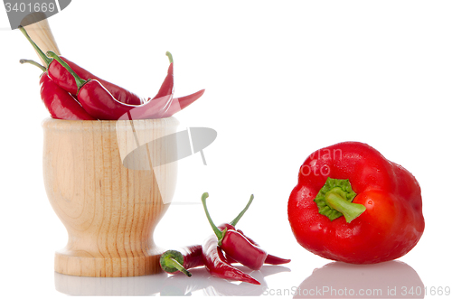 Image of Red chili and bell pepper on wooden mortar 