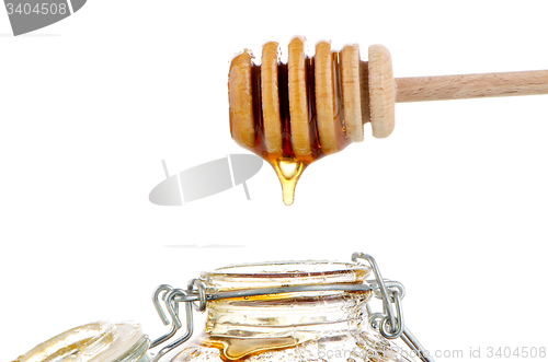 Image of Jar of honey with wooden drizzler