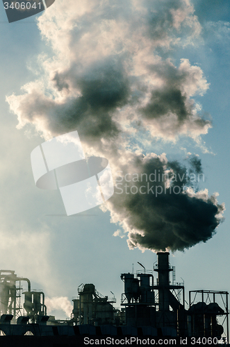 Image of Smoking chimney  at sunset 