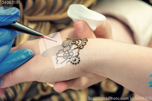 Image of A tattoo artist applying his craft onto the hand of a female