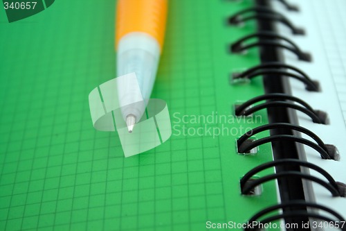 Image of Orange ballpoint pen on notebook