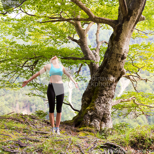 Image of Active sporty woman relaxing in beautiful nature.