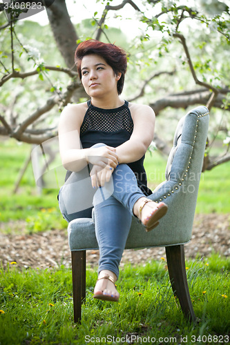 Image of Brunette Woman on a Chair Outside