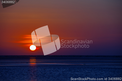 Image of Orange Ball of the Sun Dipping towards Horizon at Sunset