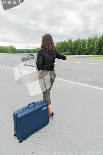 Image of Beautiful woman with suitcase. Back view