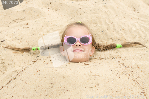 Image of Five-year girl with glasses on the beach