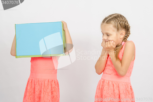 Image of The girl was frightened other girl with a box on his head