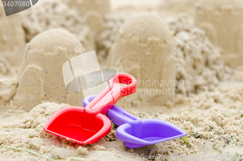 Image of Shovel and rake on the background of sand castle