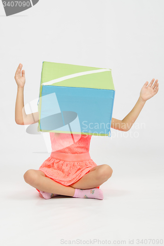 Image of The girl with a box on his head her arms