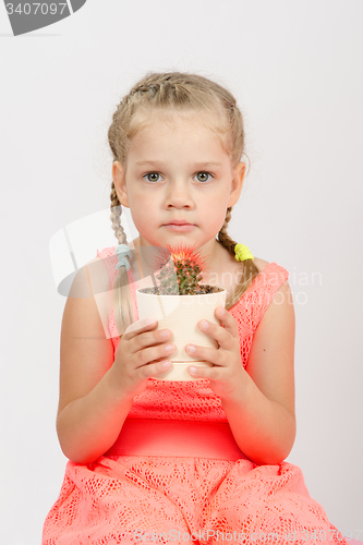 Image of Girl holding a cactus keeps